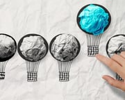 hand drawn air balloons with blue crumpled paper ball as leadership concept